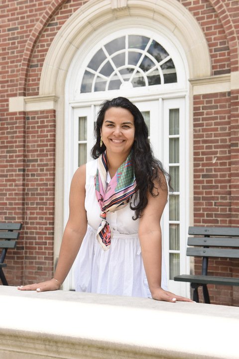 Aida Conroy stands in front of a brick building.