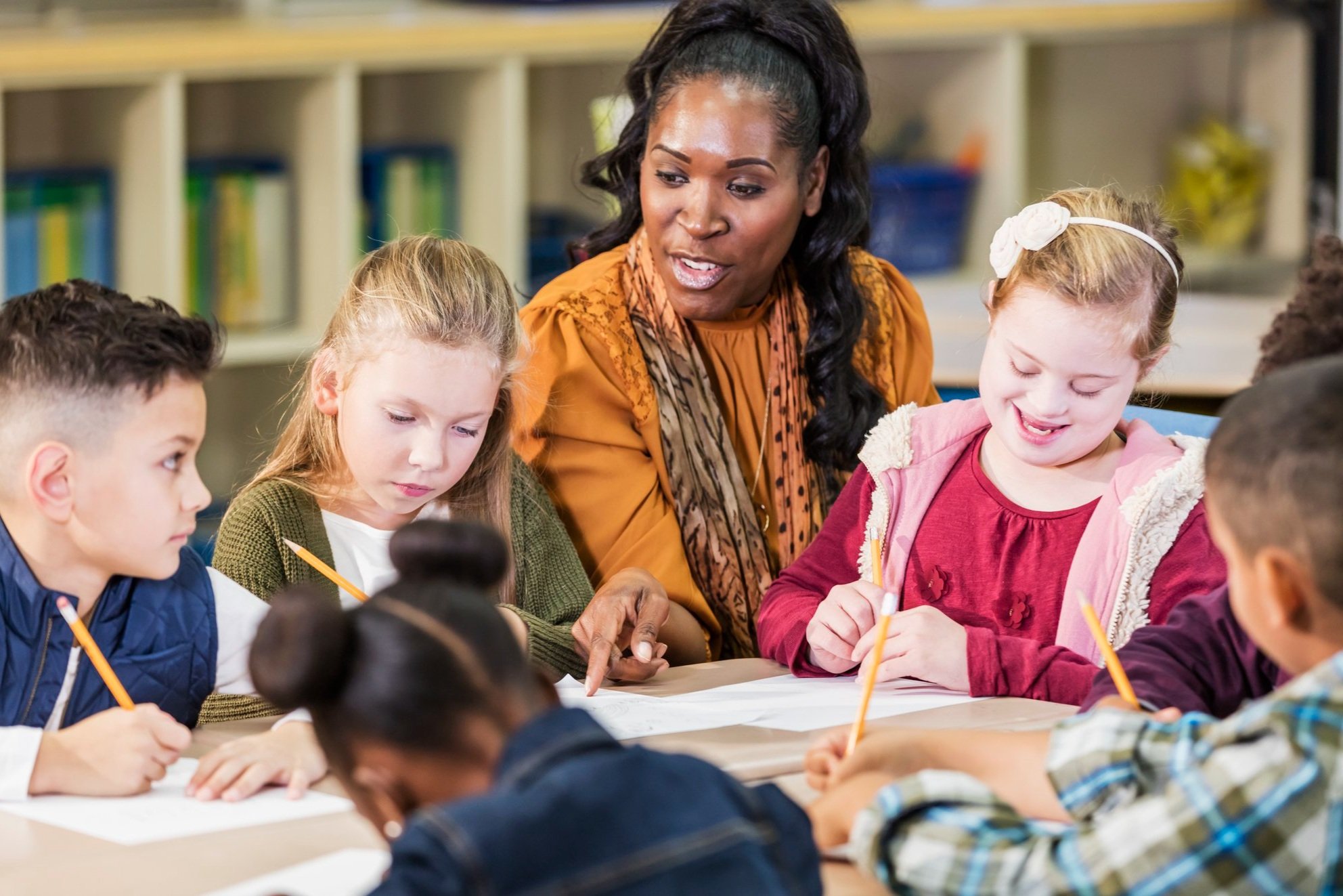 A teacher works with students in a small group.